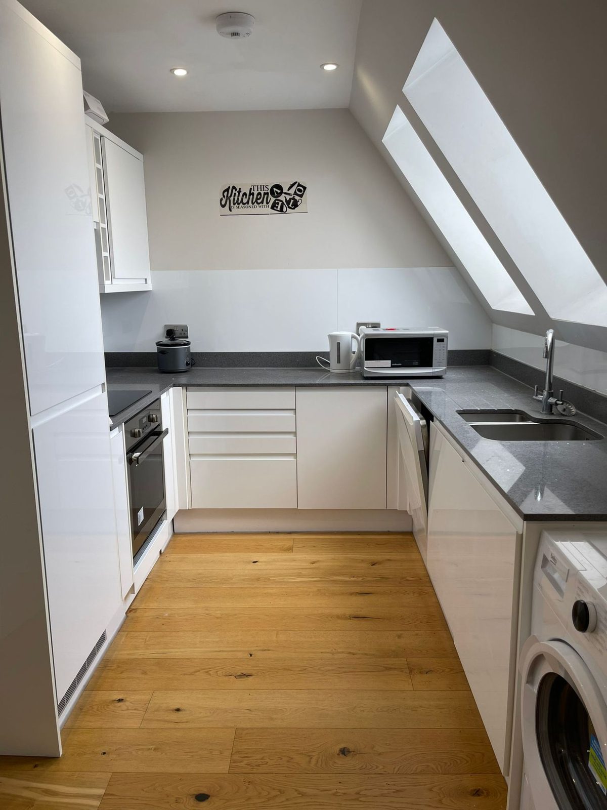 A kitchen cleaned to let: oven, hob, extractor, worktops and sink descaled and dried.